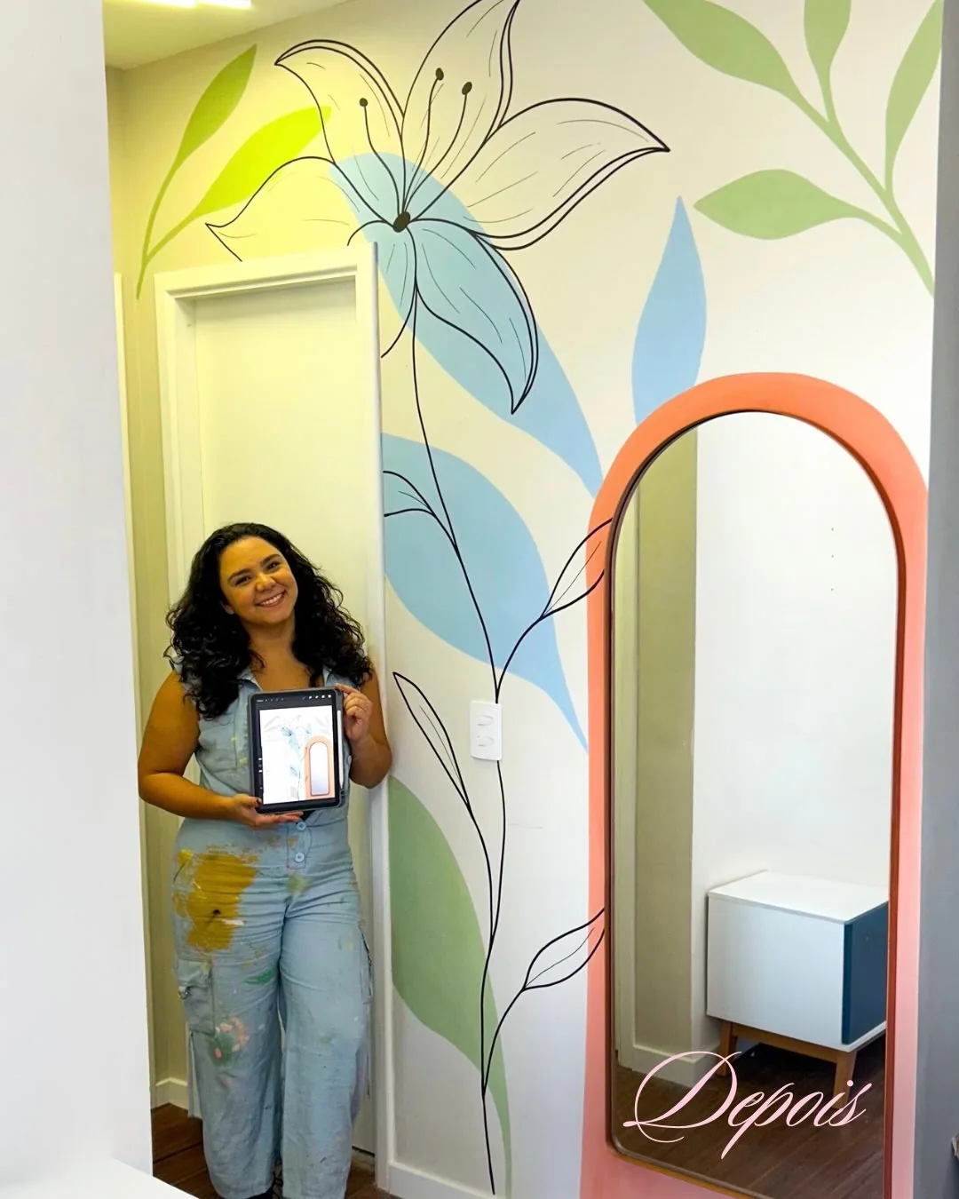 Pintura de flores e folhas em verde, azul e coral ao redor de um espelho